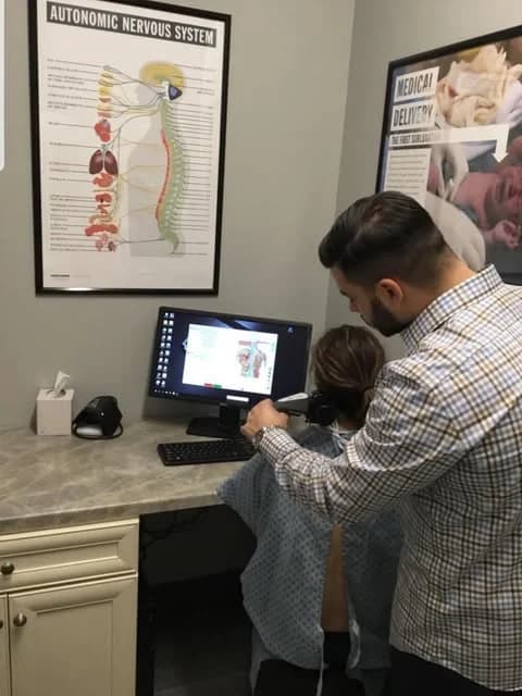Reviewing a digital X-ray with a patient at Explore Family Chiropractic in Aurora, Ohio